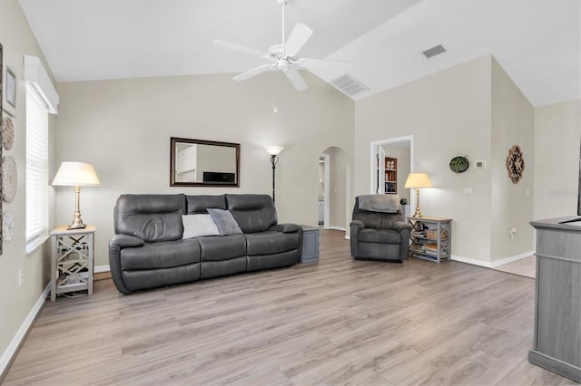 living area with arched walkways, visible vents, light wood-type flooring, and ceiling fan