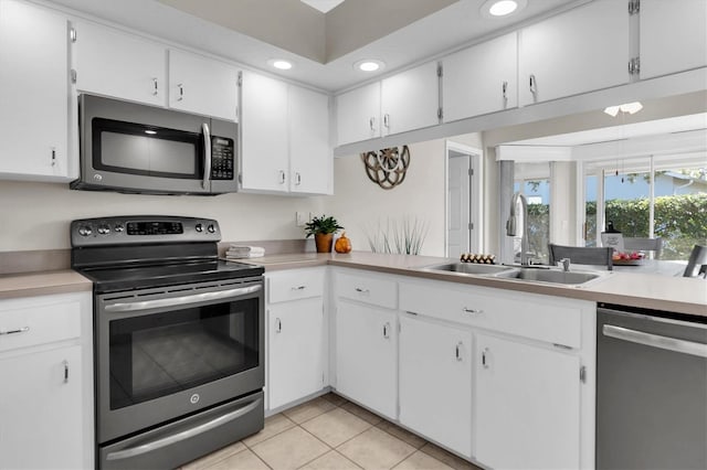 kitchen featuring light countertops, light tile patterned floors, recessed lighting, appliances with stainless steel finishes, and a sink