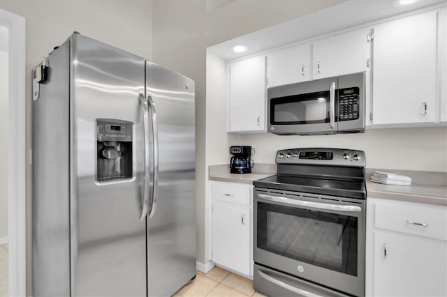 kitchen featuring white cabinetry, light countertops, light tile patterned flooring, and stainless steel appliances