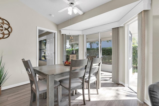 dining room with baseboards, a ceiling fan, lofted ceiling, and wood finished floors