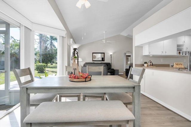 dining area featuring lofted ceiling, a ceiling fan, visible vents, and light wood finished floors