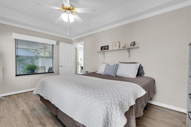 bedroom with ceiling fan, wood finished floors, baseboards, and ornamental molding