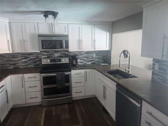 kitchen with a sink, white cabinetry, tasteful backsplash, appliances with stainless steel finishes, and dark wood-style floors