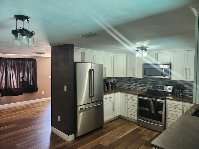 kitchen featuring dark countertops, tasteful backsplash, dark wood-style flooring, and stainless steel appliances