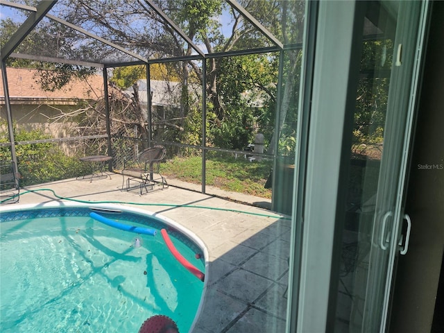outdoor pool with a lanai and a patio area