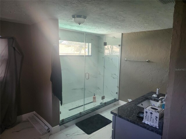 bathroom with a sink, marble finish floor, a textured ceiling, and a marble finish shower