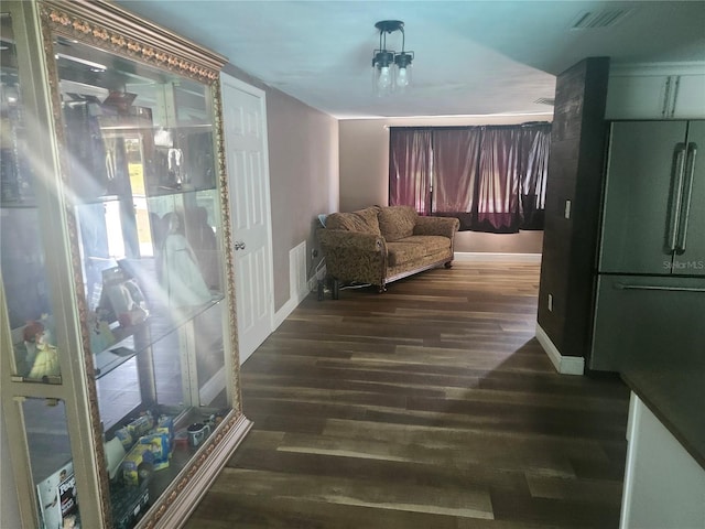 interior space with baseboards, dark wood-style floors, and visible vents