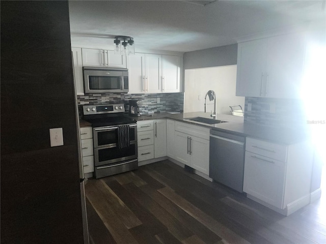 kitchen with decorative backsplash, white cabinetry, a sink, and stainless steel appliances
