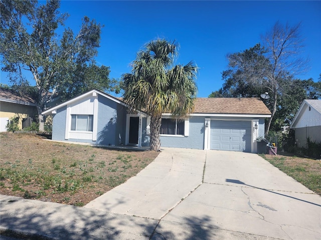 view of front of home with stucco siding, driveway, and a garage
