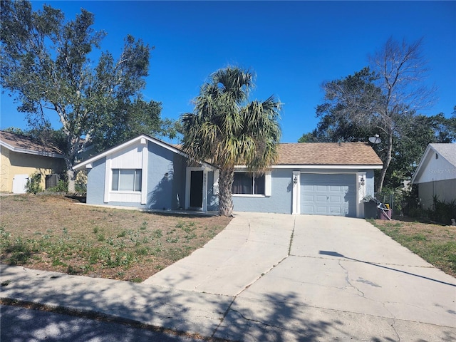 view of front of house with driveway, a garage, and stucco siding