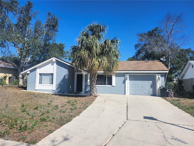 view of front facade with stucco siding, an attached garage, and concrete driveway
