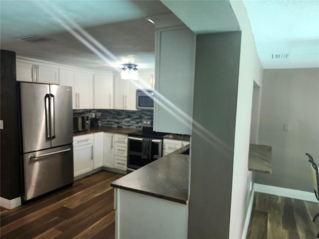 kitchen with white cabinetry, dark countertops, dark wood-style flooring, and stainless steel appliances