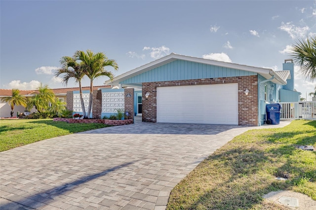 ranch-style home featuring brick siding, a front yard, decorative driveway, and a garage