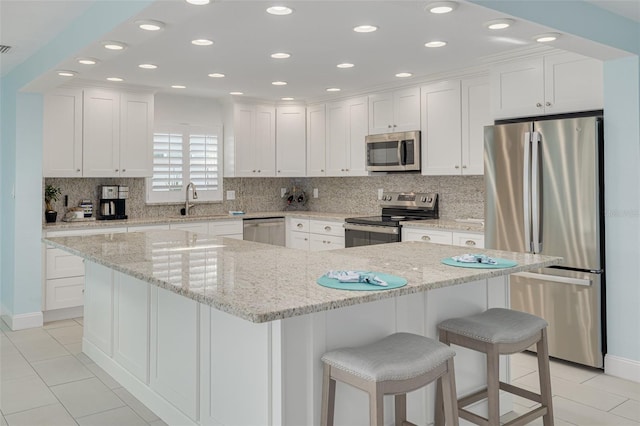 kitchen featuring white cabinetry, decorative backsplash, appliances with stainless steel finishes, and a sink