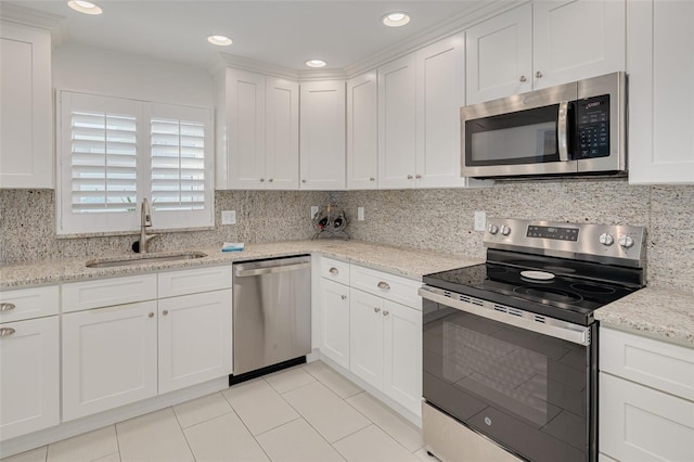 kitchen featuring backsplash, recessed lighting, white cabinets, stainless steel appliances, and a sink