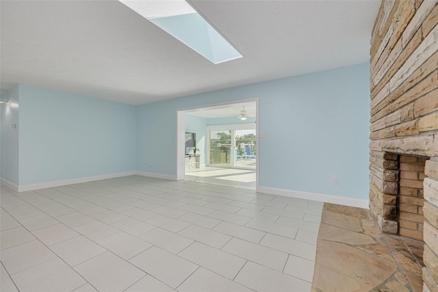 unfurnished living room featuring baseboards and a skylight