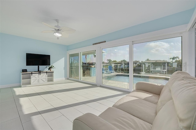 living room featuring tile patterned floors, baseboards, and ceiling fan