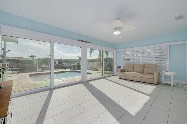 tiled living area with visible vents, baseboards, and ceiling fan