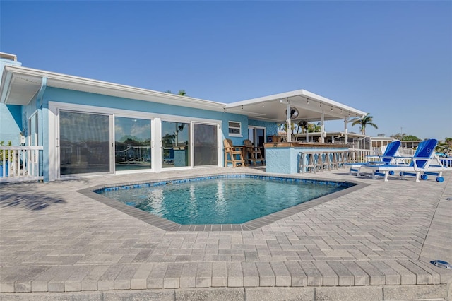 outdoor pool featuring outdoor dry bar and a patio area