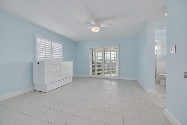 spare room featuring light tile patterned floors, baseboards, and a ceiling fan