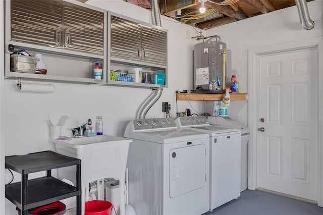 clothes washing area featuring washer and dryer, cabinet space, and electric water heater