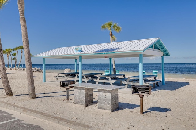 view of community with a gazebo, a beach view, and a water view