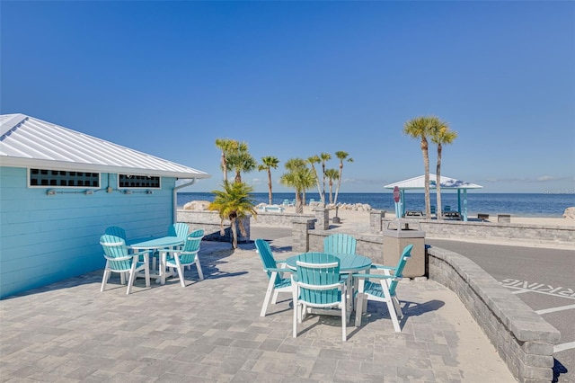 view of patio with outdoor dining space and a water view