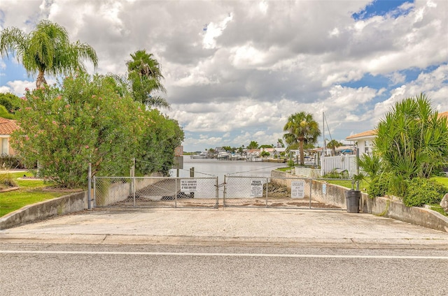 exterior space with a fenced front yard, a water view, and a gate