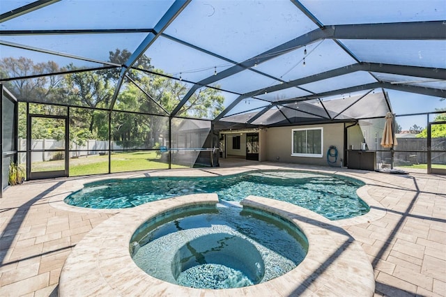 view of swimming pool with a patio, a fenced backyard, a pool with connected hot tub, and a lanai