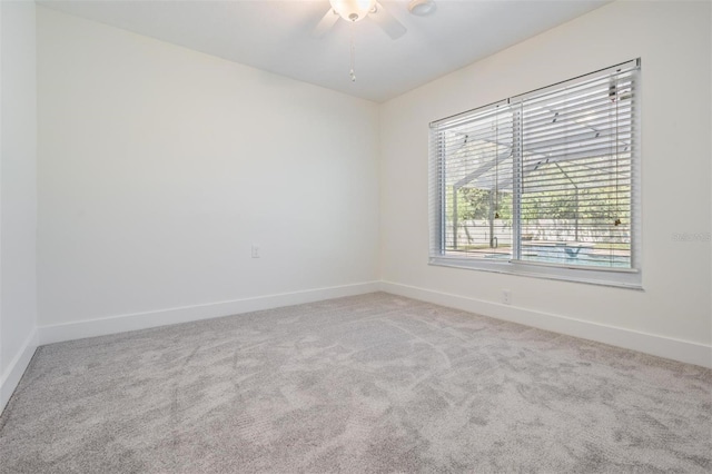 spare room with carpet flooring, a ceiling fan, and baseboards