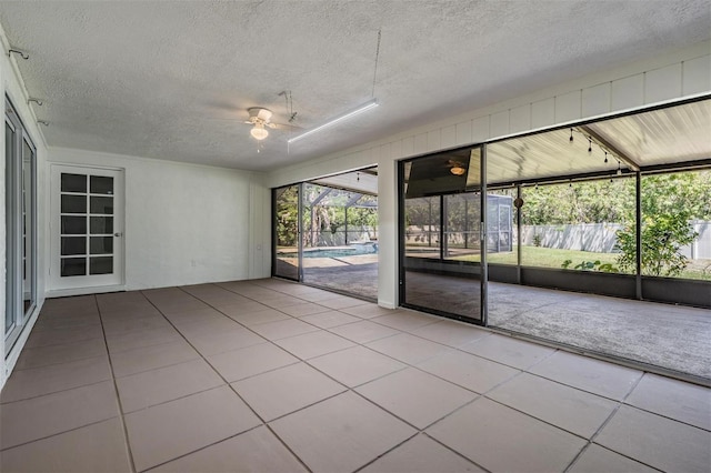 unfurnished sunroom with ceiling fan