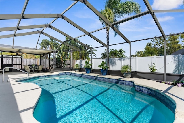 view of swimming pool featuring glass enclosure, a patio, a fenced backyard, and a fenced in pool