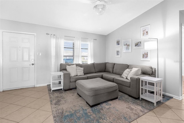 living area with baseboards, light tile patterned flooring, and a ceiling fan