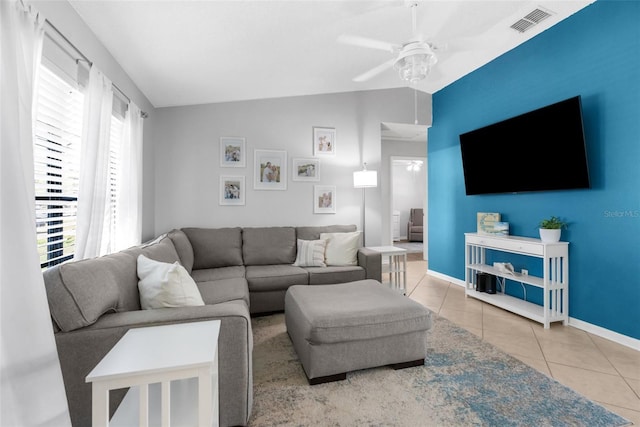 tiled living area with visible vents, baseboards, ceiling fan, and vaulted ceiling