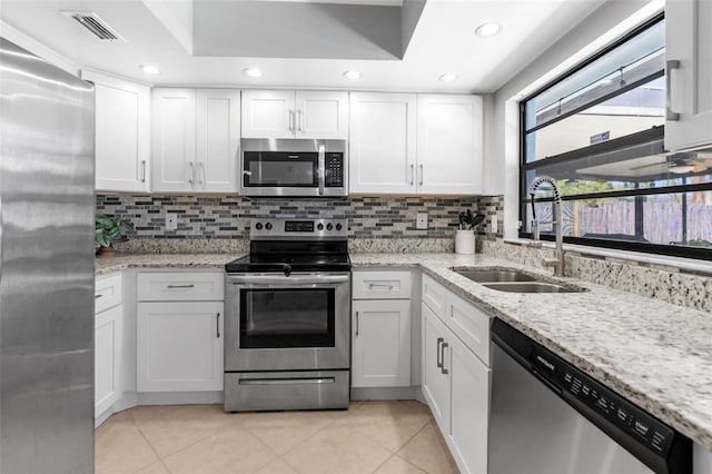 kitchen featuring a sink, stainless steel appliances, visible vents, and white cabinetry