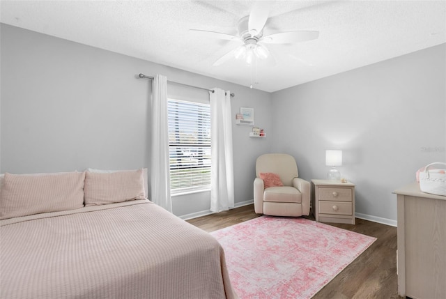 bedroom with baseboards, a textured ceiling, wood finished floors, and a ceiling fan