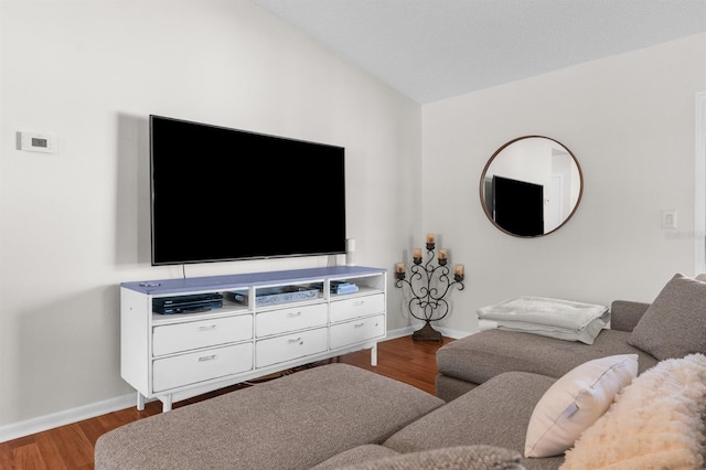 living room with lofted ceiling, wood finished floors, and baseboards