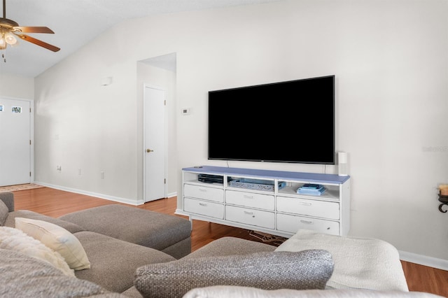 living area featuring baseboards, wood finished floors, ceiling fan, and vaulted ceiling