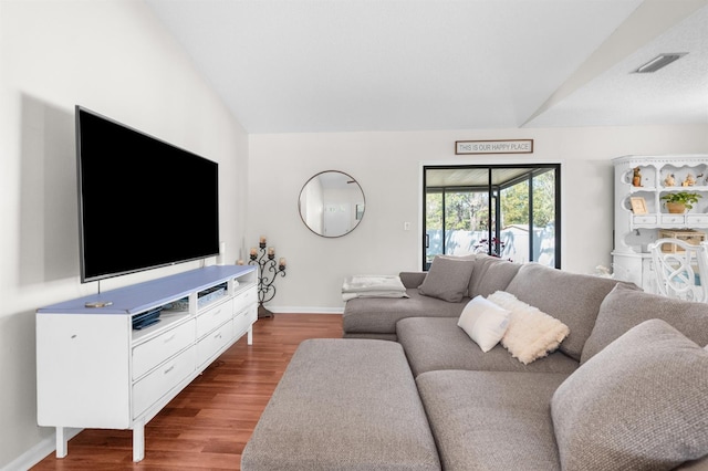 living area with visible vents, lofted ceiling, baseboards, and wood finished floors