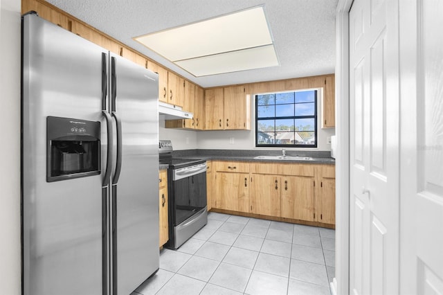 kitchen with dark countertops, under cabinet range hood, stainless steel appliances, a textured ceiling, and a sink