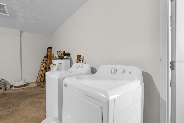 laundry area featuring visible vents, a textured ceiling, washing machine and dryer, water heater, and laundry area