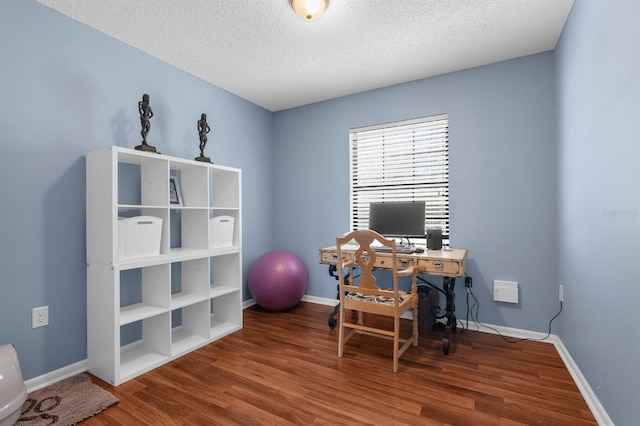 office featuring a textured ceiling, baseboards, and wood finished floors