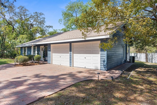 ranch-style house featuring central AC unit, an attached garage, and fence