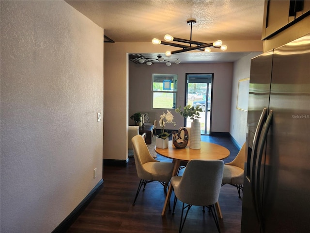 dining room with an inviting chandelier, wood finished floors, baseboards, and a textured wall