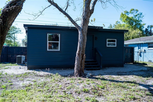 back of house featuring central AC unit and fence