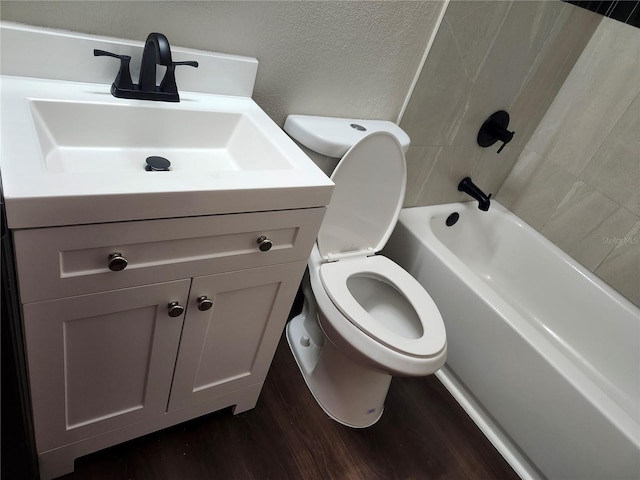 full bathroom featuring toilet, wood finished floors, vanity, and a textured wall