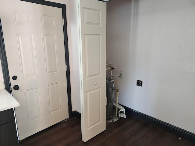 washroom with hookup for an electric dryer, dark wood-type flooring, and baseboards