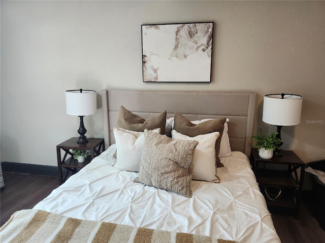 bedroom featuring baseboards and wood finished floors