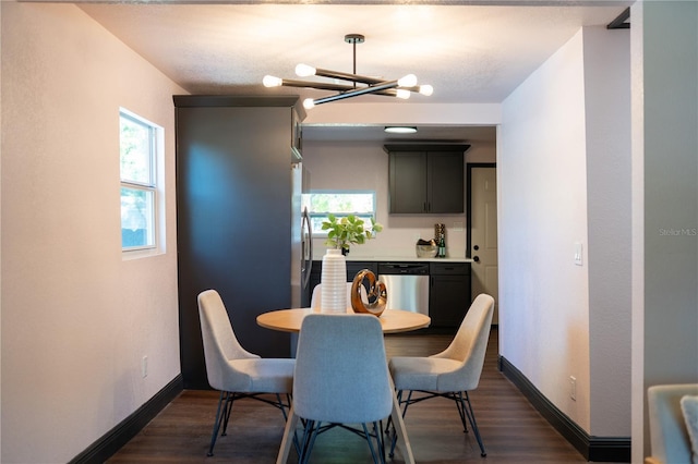 dining space with baseboards, dark wood-style flooring, and a chandelier