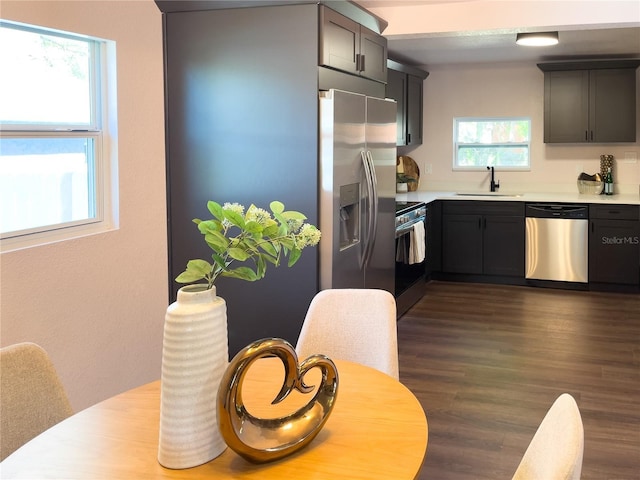 kitchen featuring light countertops, dark wood-style floors, appliances with stainless steel finishes, and a sink